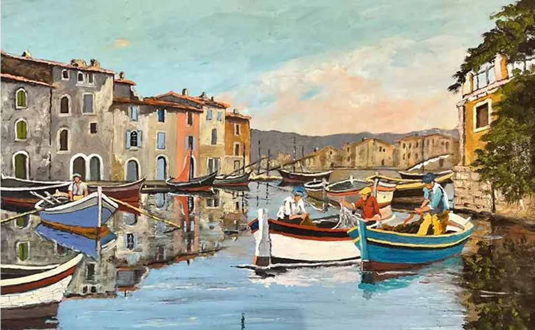 Reflets d'un canal bordé de maisons méditerranéennes colorées et de barques amarrées, ciel clair en arrière-plan.