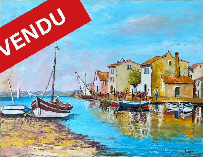 Port provençal animé avec voiliers et barques de pêche amarrées, village aux toits ocre ; un bandeau rouge « VENDU » barre l'image.